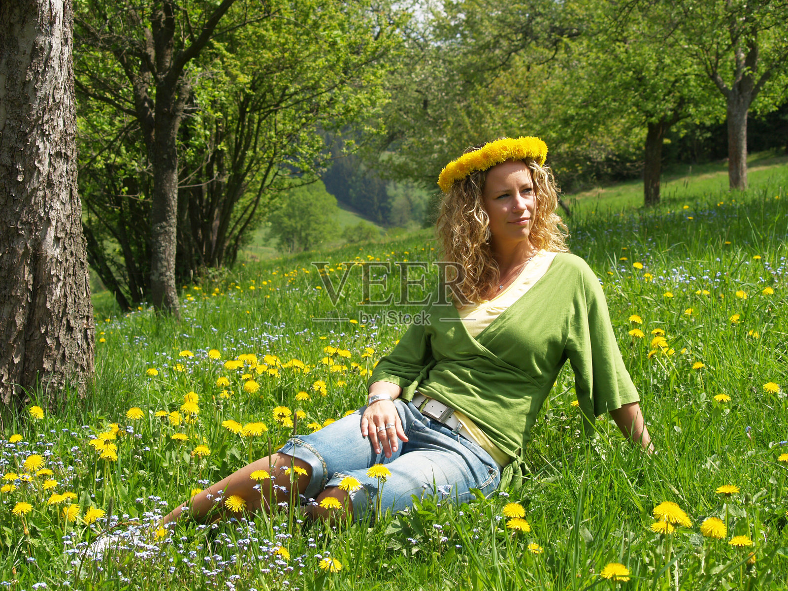 卷毛女孩戴着蒲公英链照片摄影图片