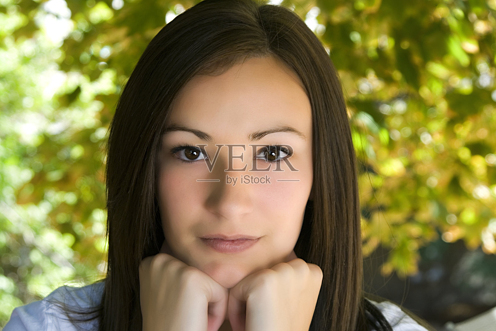 美丽的少年与树叶的背景照片摄影图片