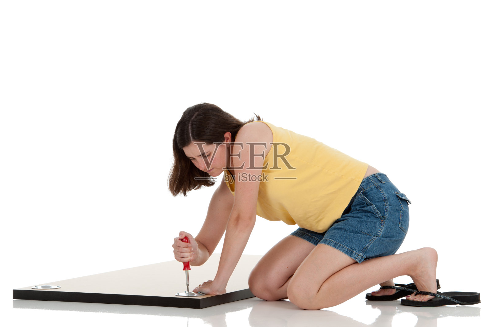 脾气暴躁的女人在组装桌子照片摄影图片