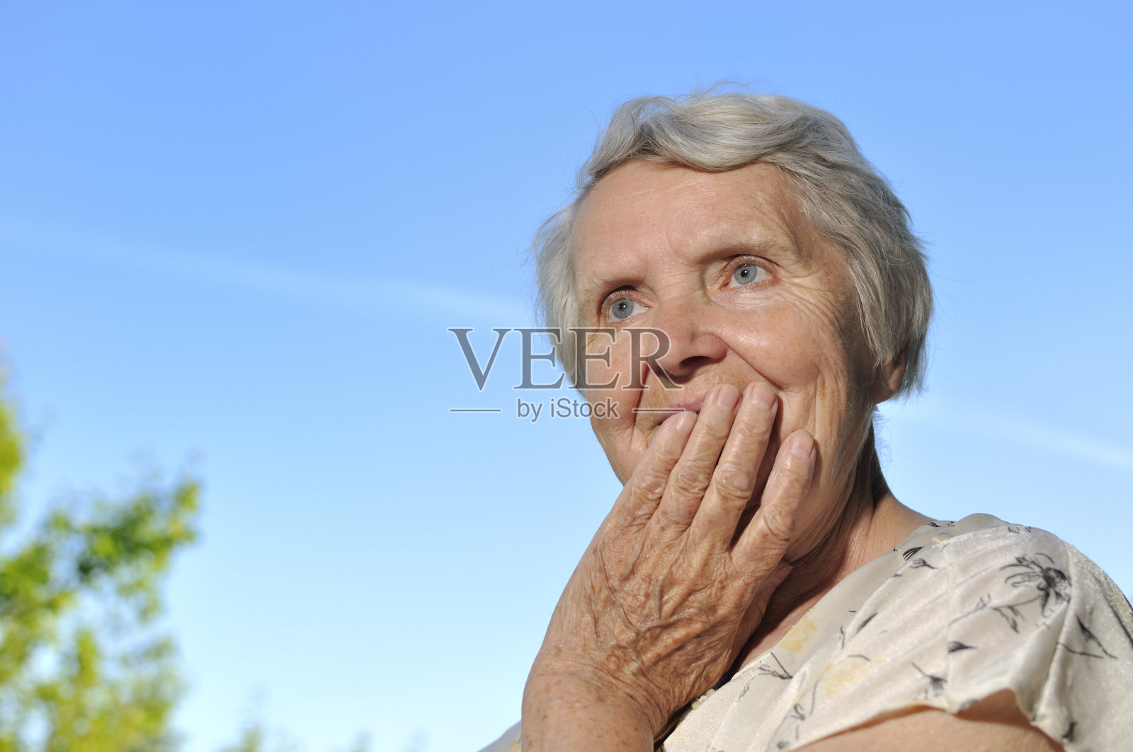 快乐的老妇人抬头望着天空。照片摄影图片
