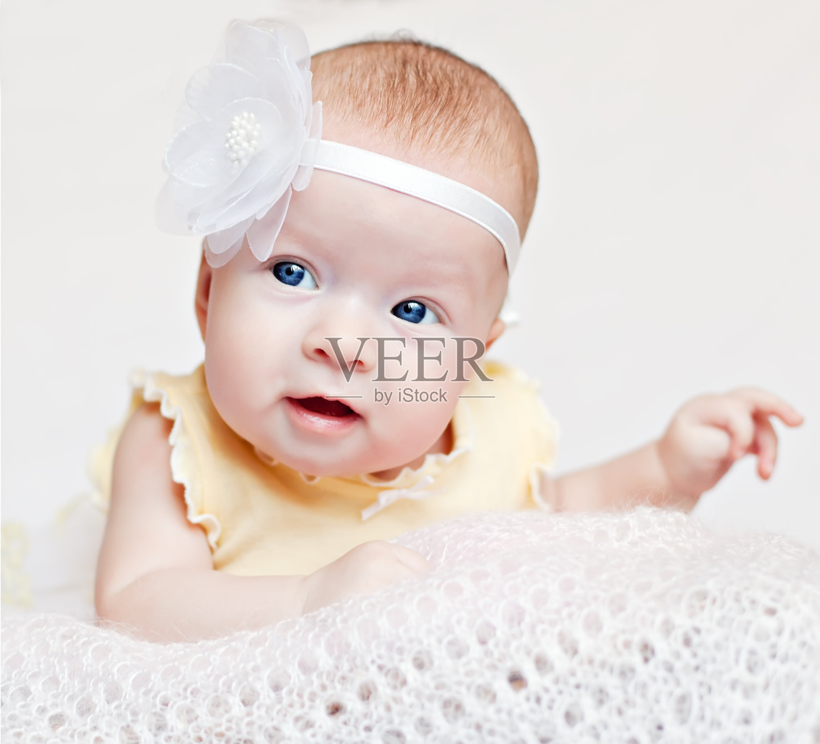 可爱的新生儿带着花的微笑照片摄影图片