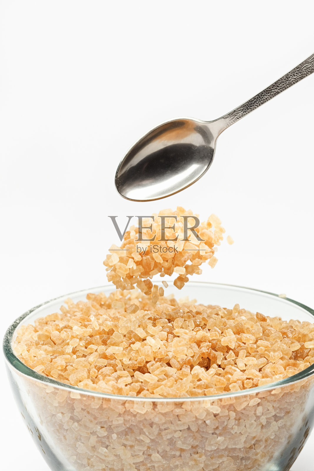 甘蔗糖从茶匙上掉下来照片摄影图片