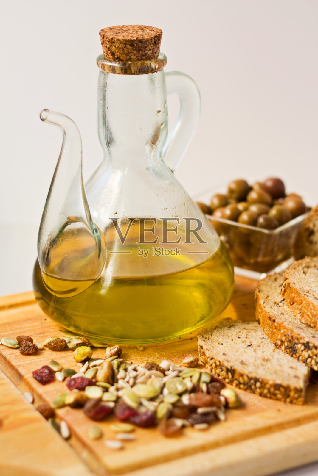 一壶橄榄油和橄榄。照片摄影图片