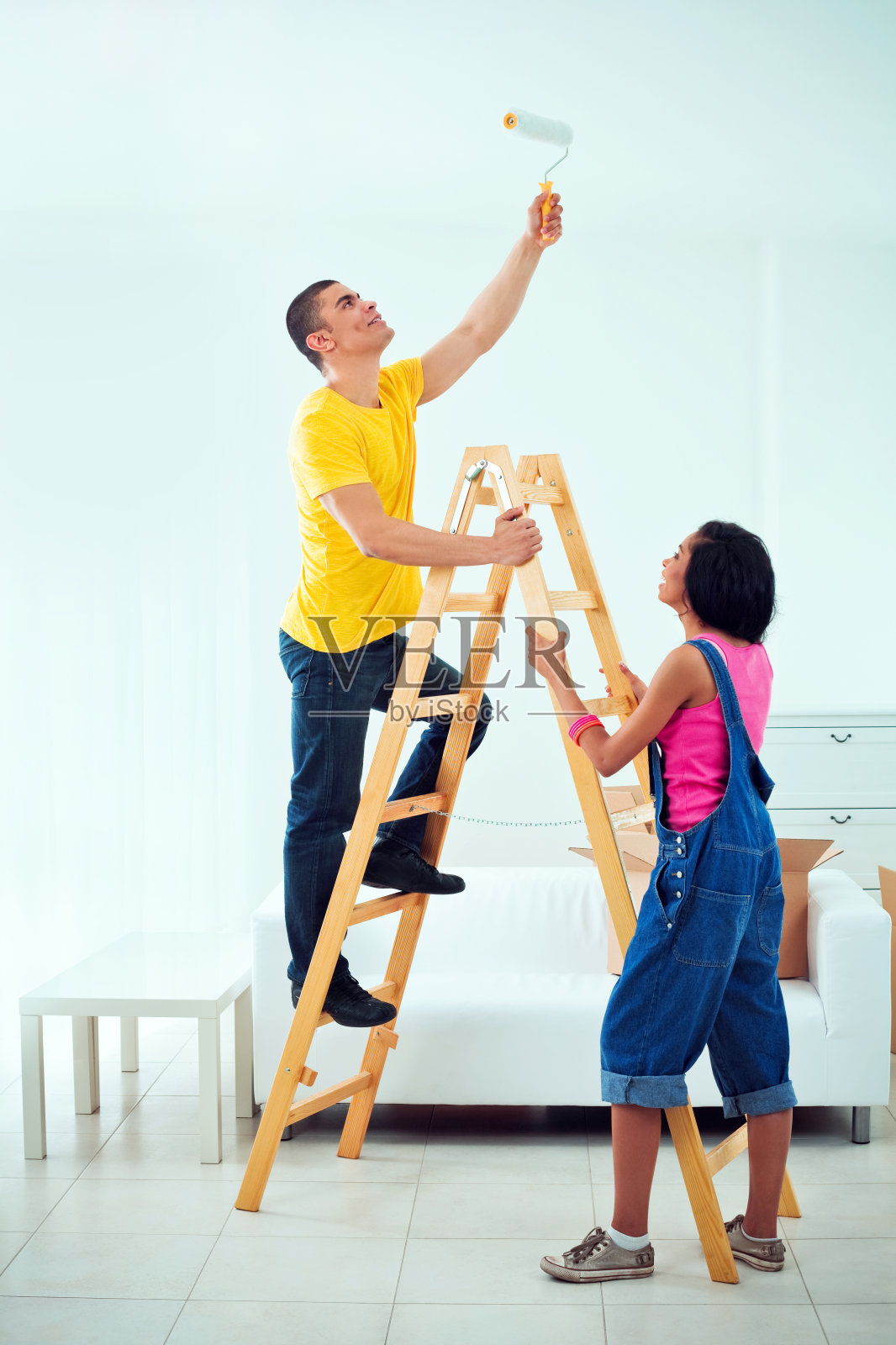 年轻夫妇粉刷公寓照片摄影图片