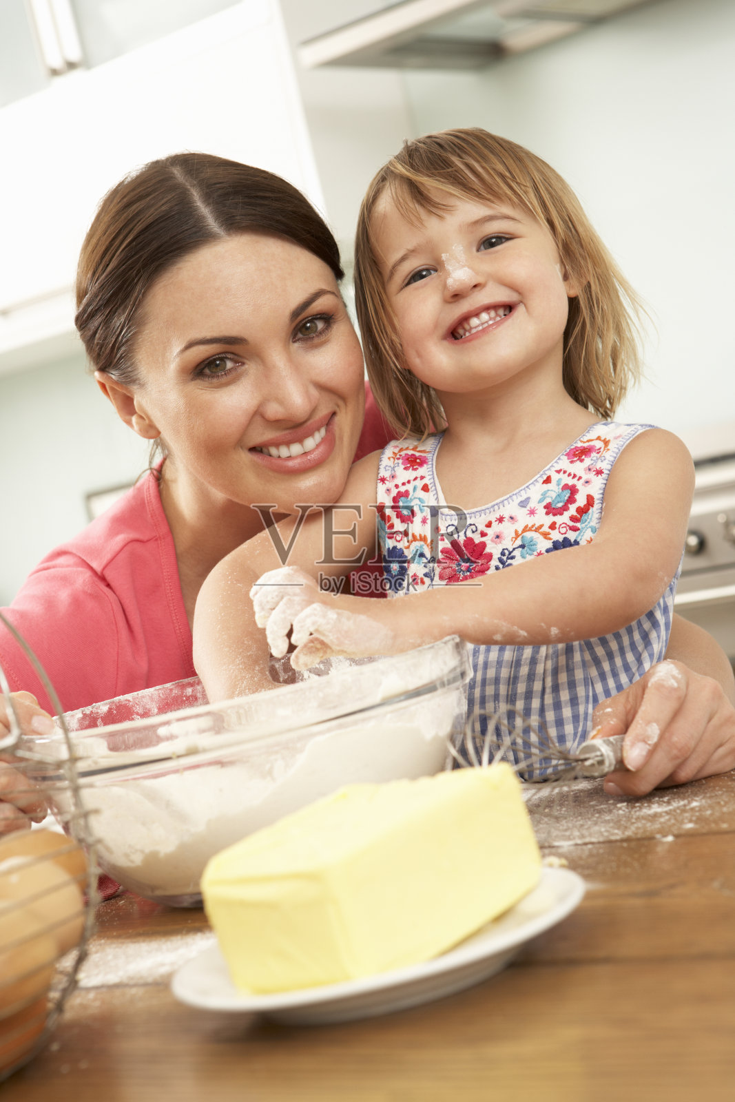 小女孩在厨房里帮妈妈烤蛋糕照片摄影图片