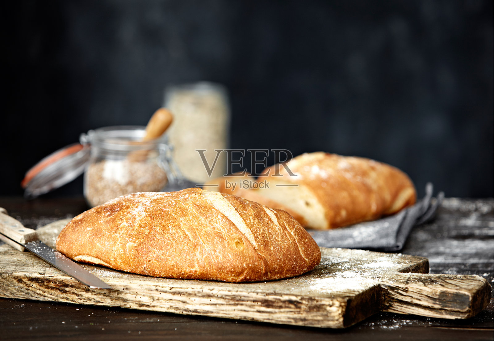 美味的面包放在旧砧板上，背景是面粉照片摄影图片