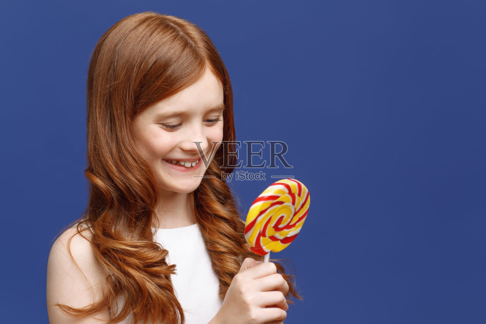 拿着棒棒糖的漂亮女孩照片摄影图片