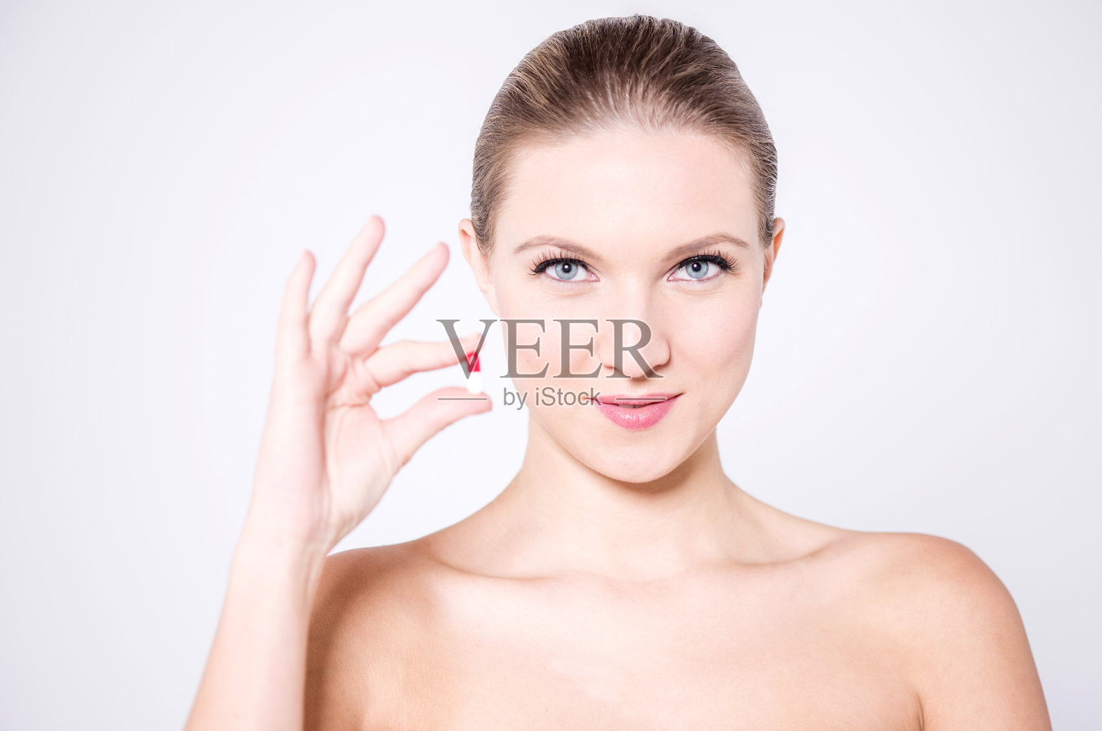 诱人的女性模特持有胶囊照片摄影图片