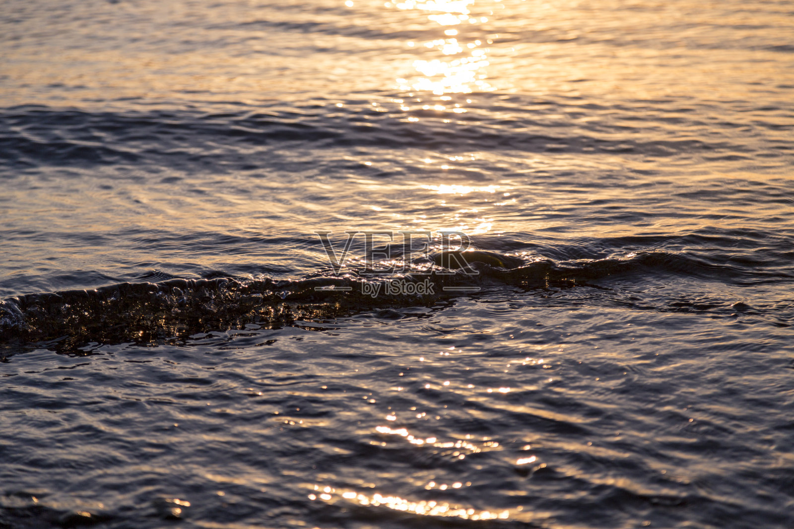 夕阳下的海洋涟漪作为背景照片摄影图片
