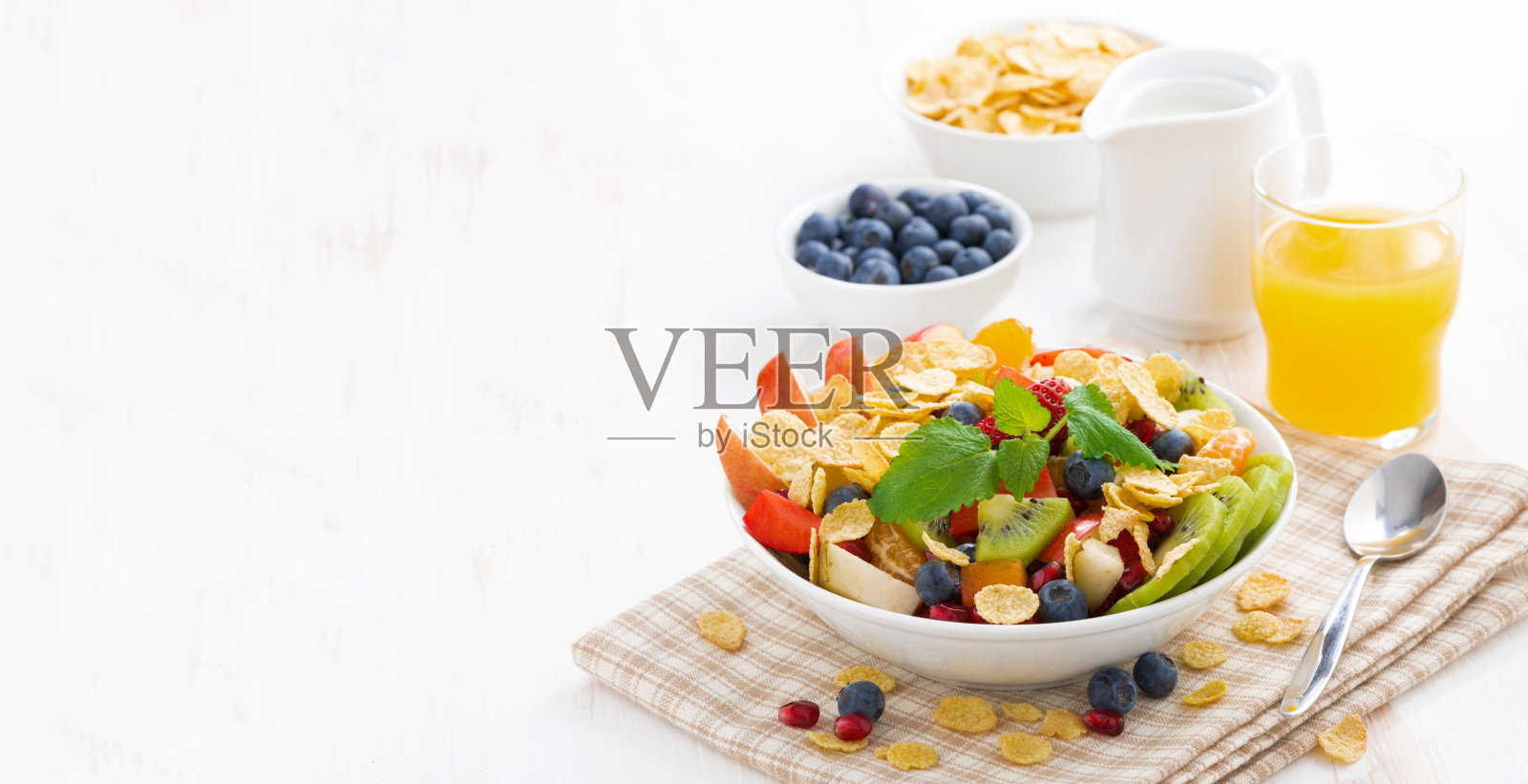 早餐有水果和浆果沙拉，果汁，麦片照片摄影图片
