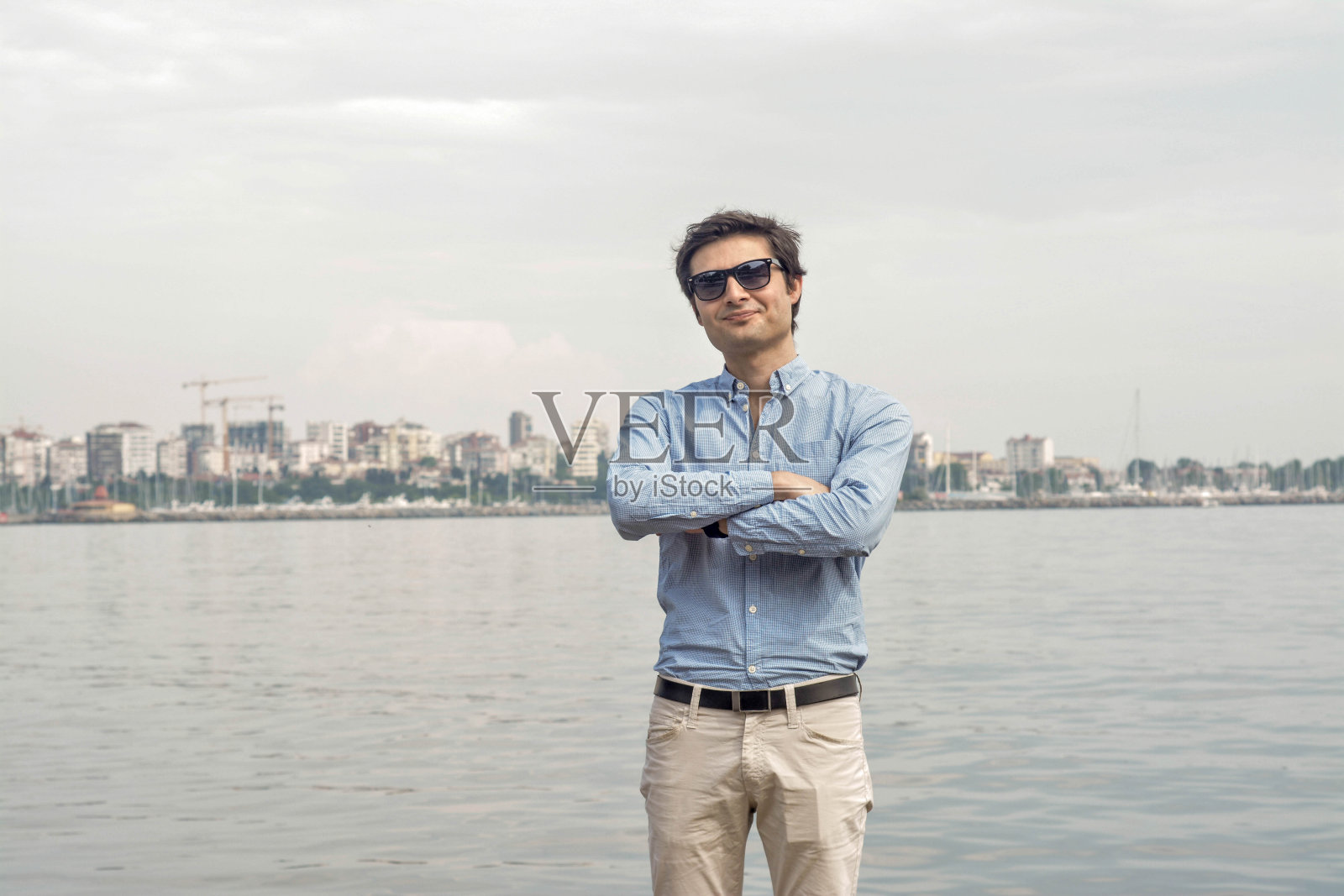 商人海背景概念:双臂交叉表情照片摄影图片