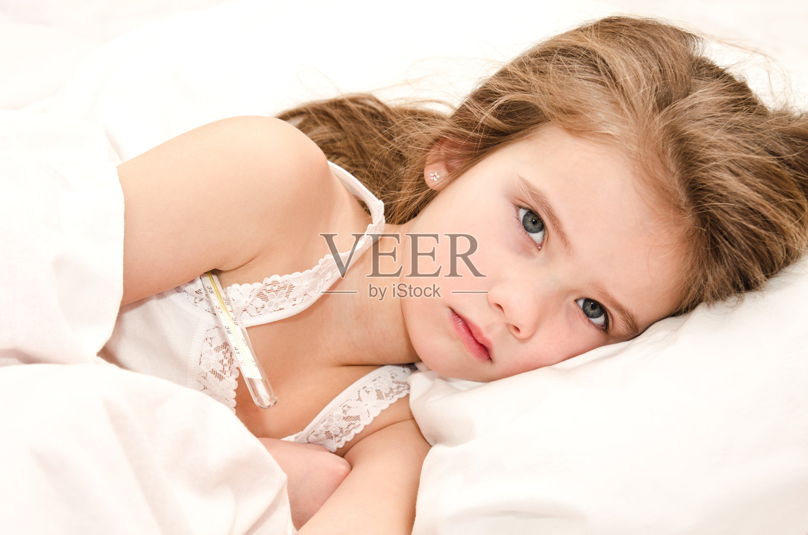 生病的小女孩躺在床上照片摄影图片