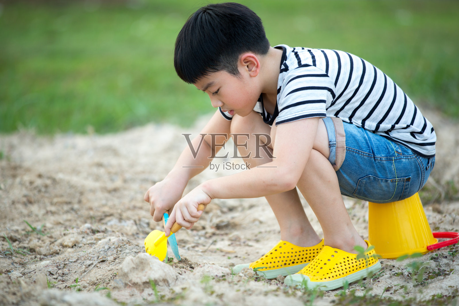 亚洲男孩在花园里玩玩具照片摄影图片