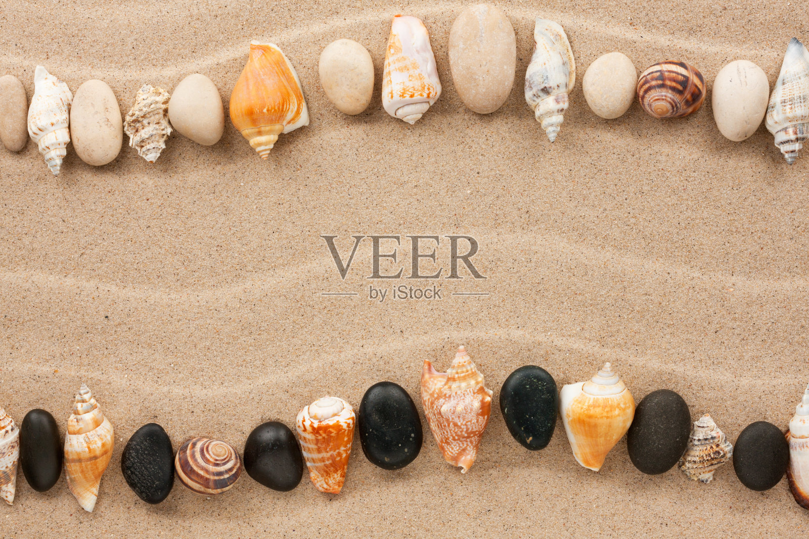 沙滩上散落着条纹状的贝壳和石头照片摄影图片