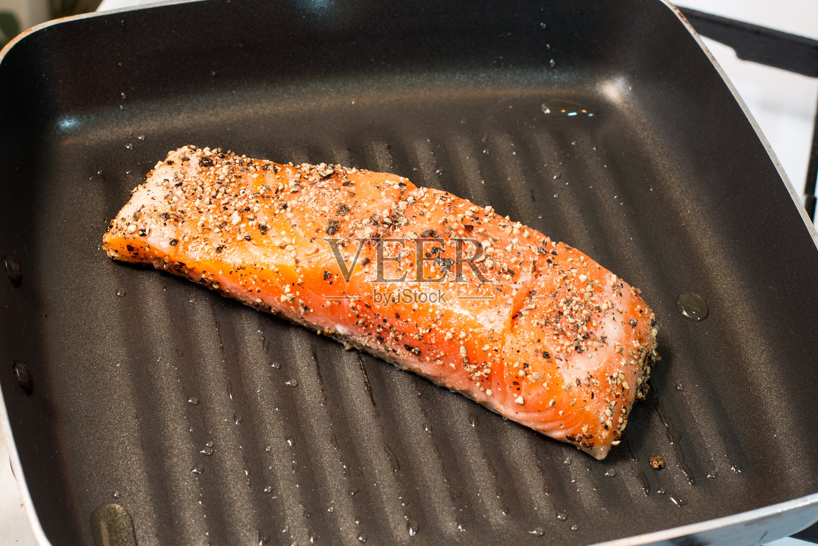 热锅里的烤鲑鱼照片摄影图片