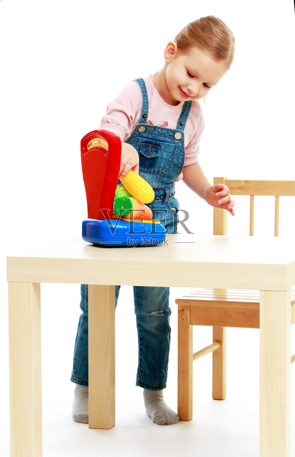 小女孩挂在平衡的水果上。照片摄影图片