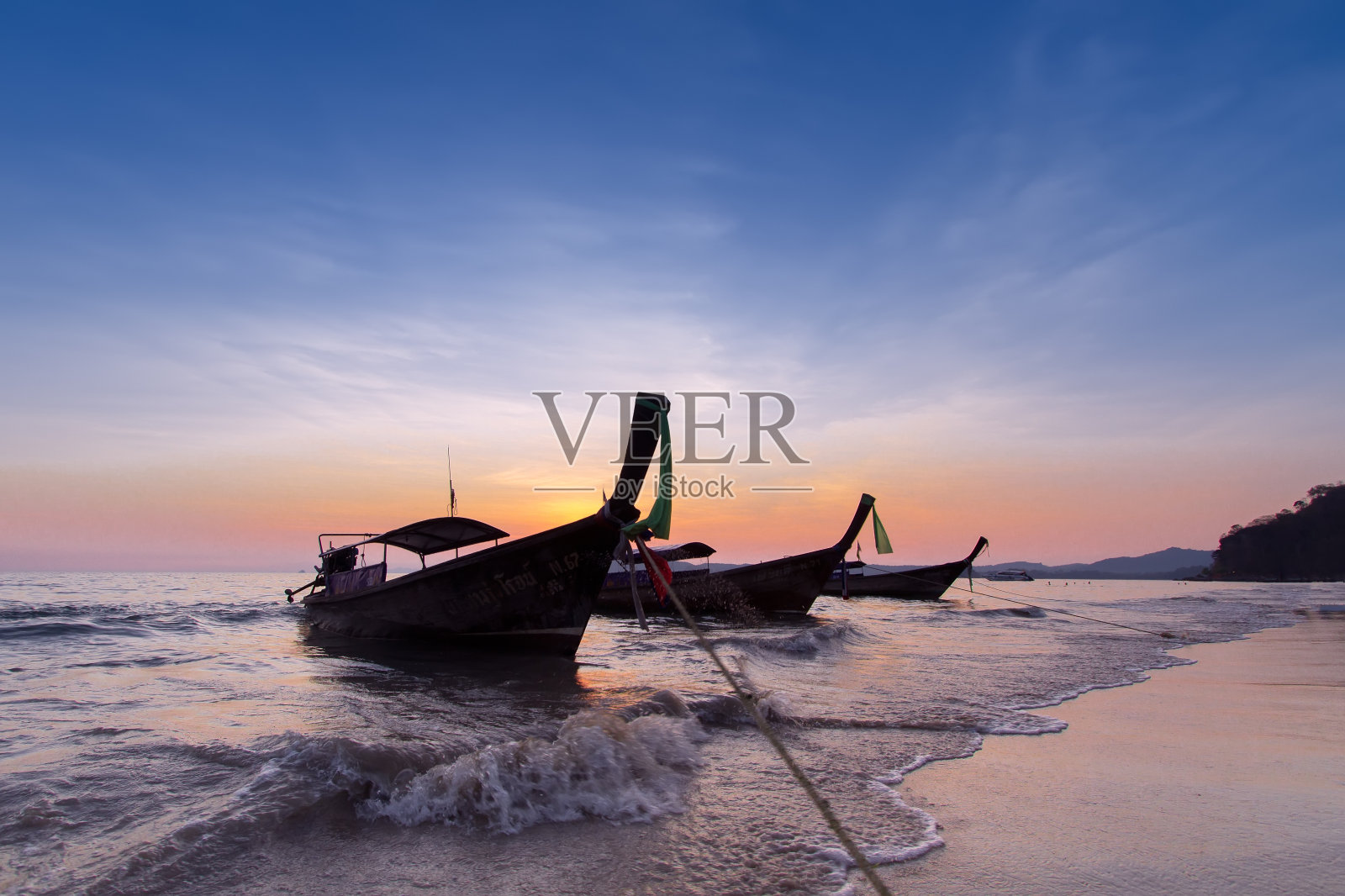 晚上沙滩上的长尾船照片摄影图片