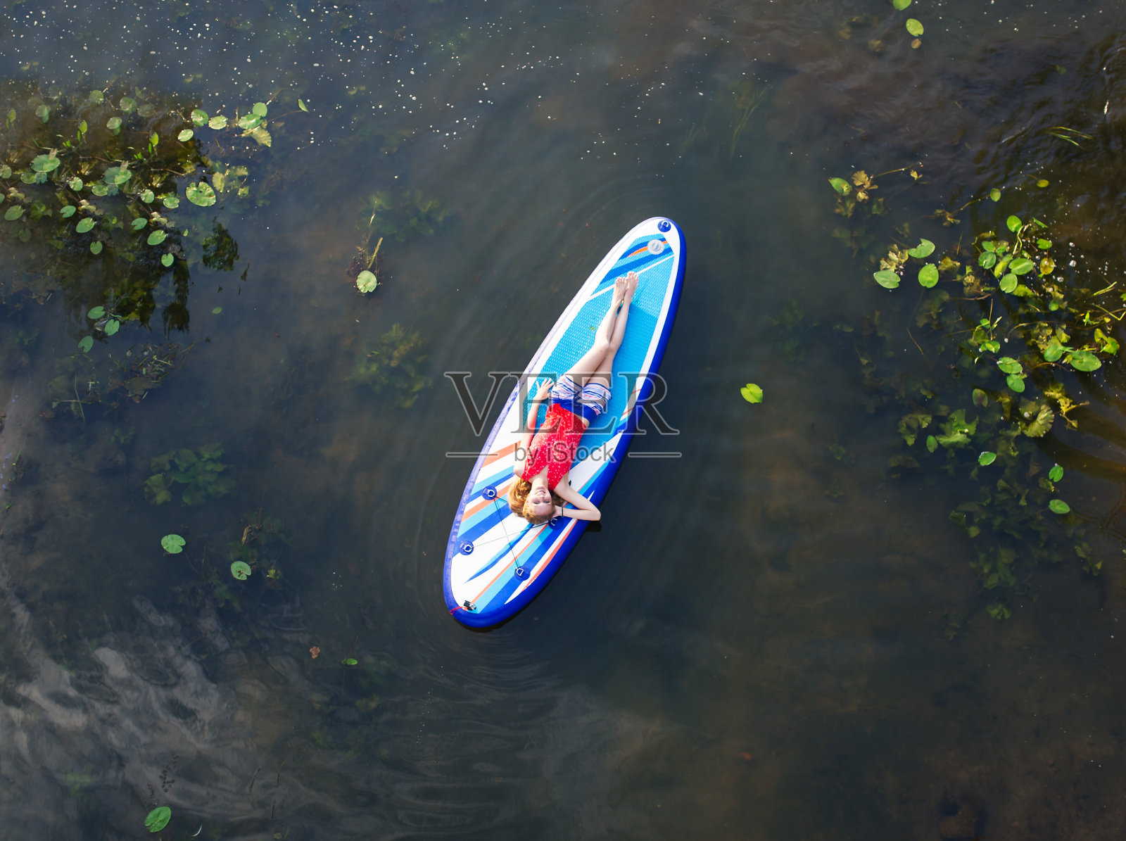 美丽的女孩躺在冲浪板上照片摄影图片