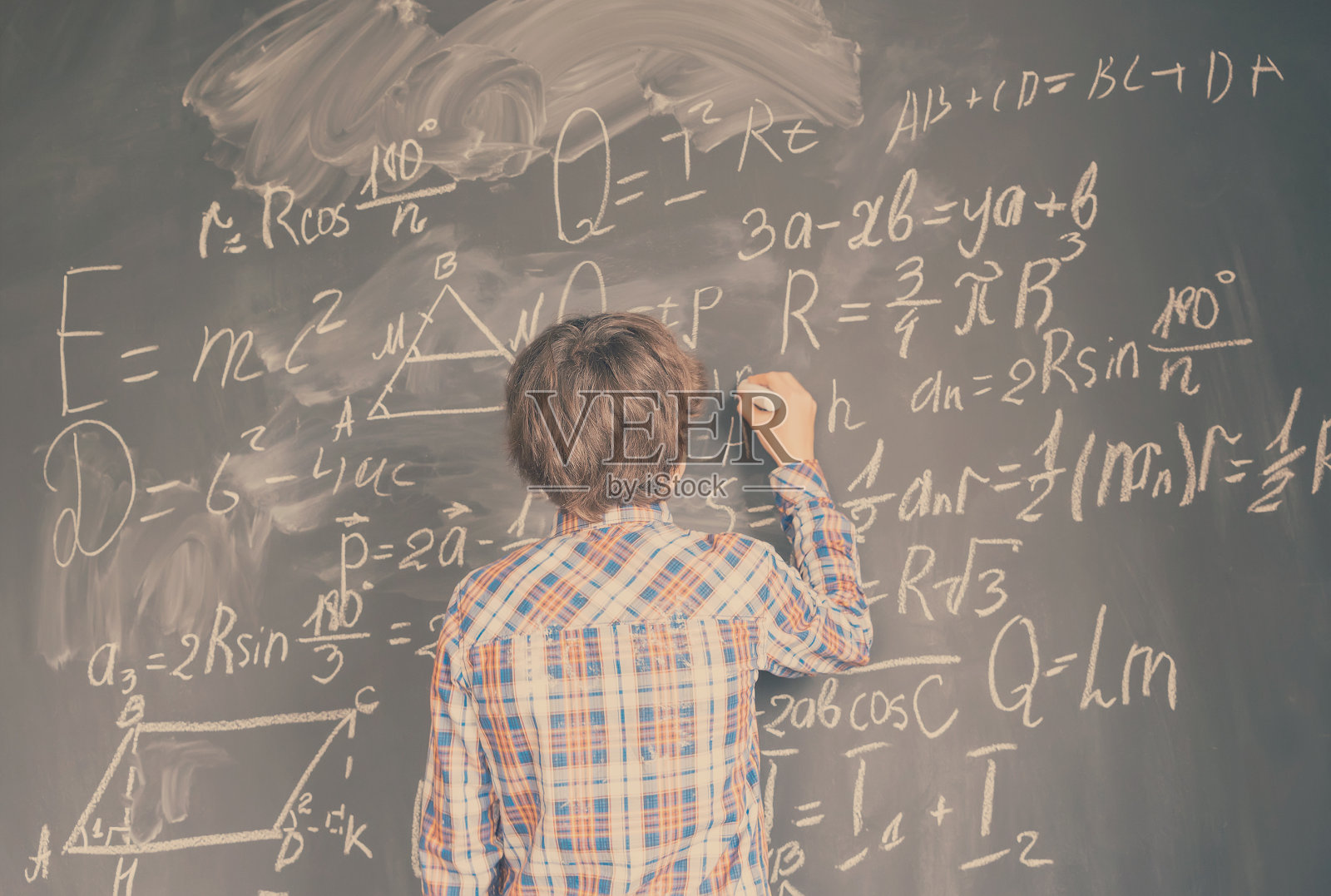 男孩在黑板上写字照片摄影图片