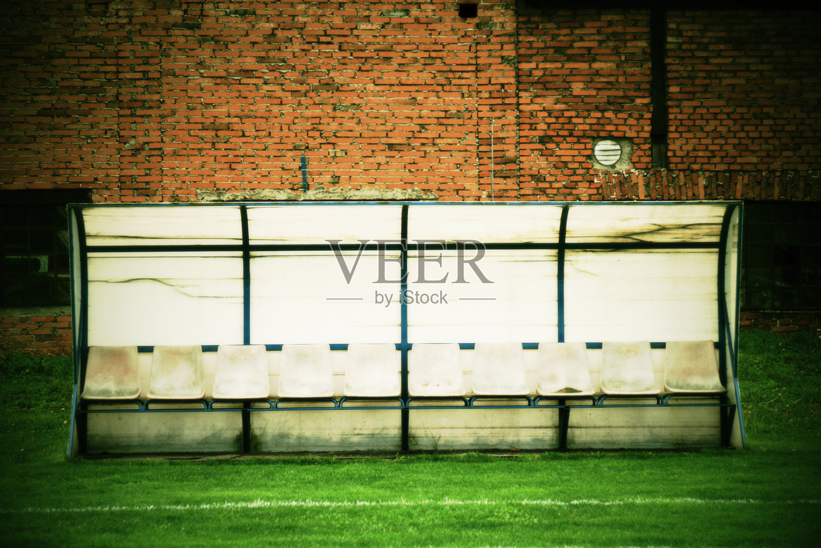 旧的塑料座椅放在户外体育场的球员板凳、椅子上照片摄影图片