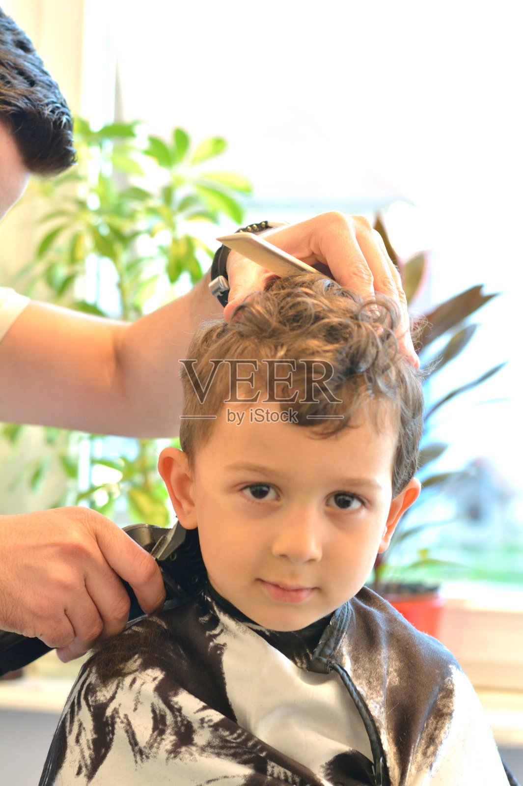 可爱的小男孩在美发师。照片摄影图片