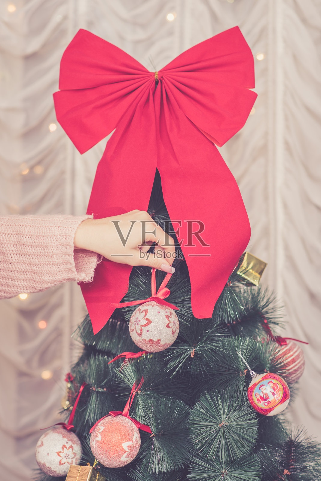 女人手里拿着圣诞树上的装饰品照片摄影图片