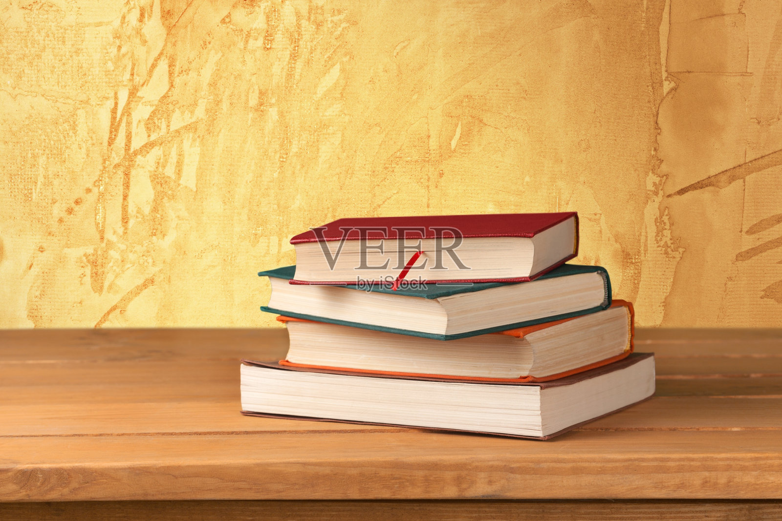 老式的书在木制的甲板桌上靠在垃圾墙照片摄影图片