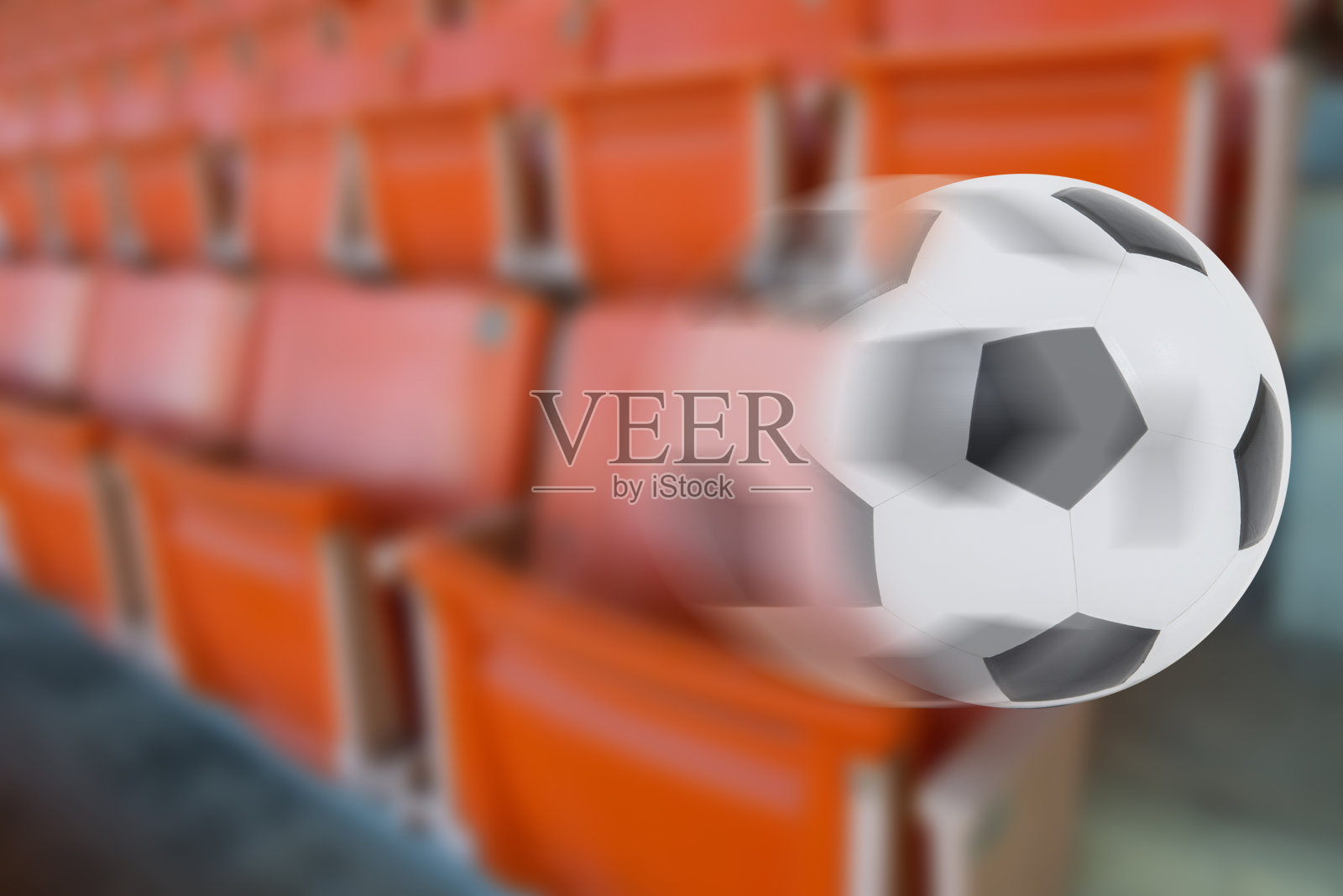 足球滚动在模糊体育场座位的背景照片摄影图片