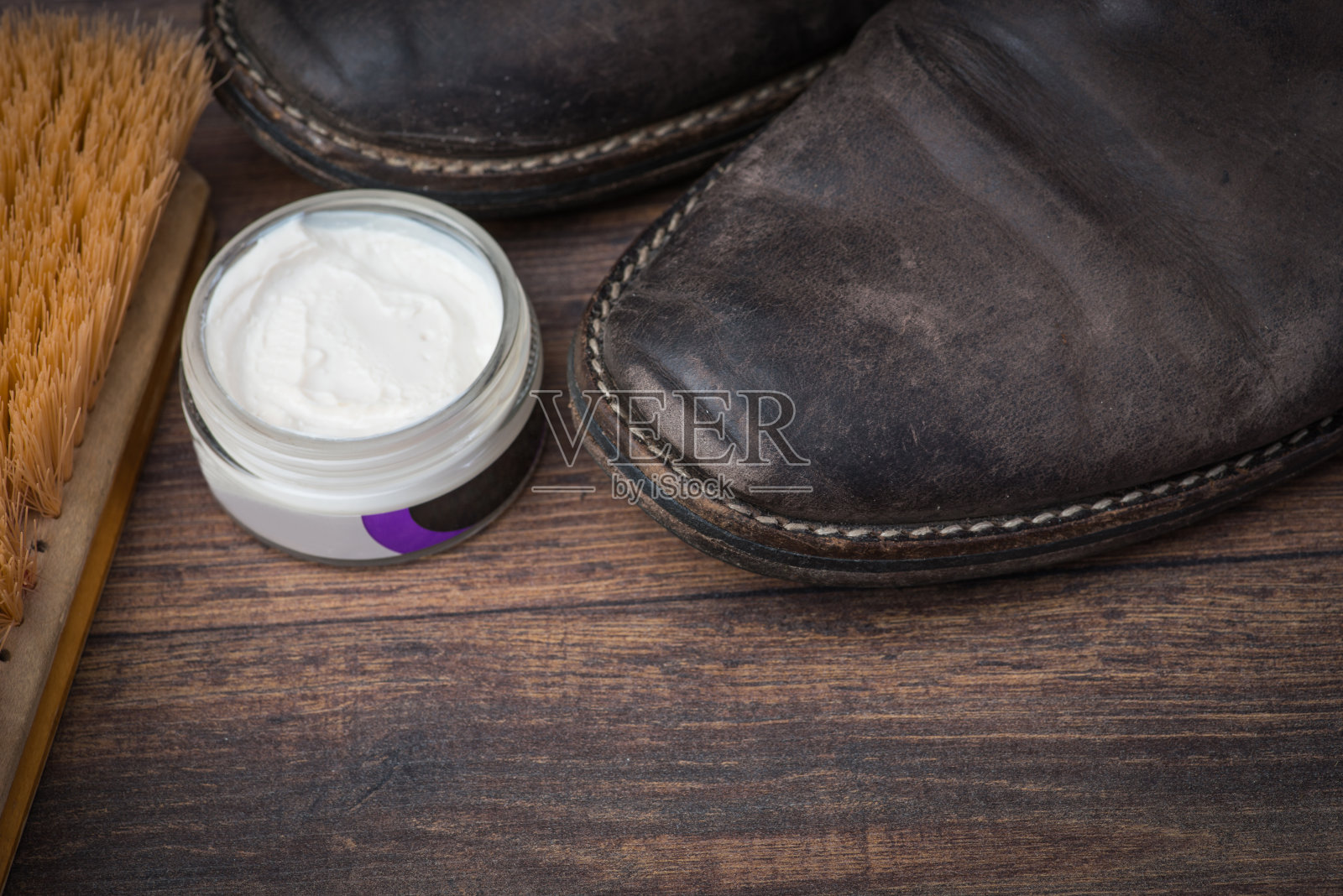 破旧的棕色皮鞋配着奶油照片摄影图片