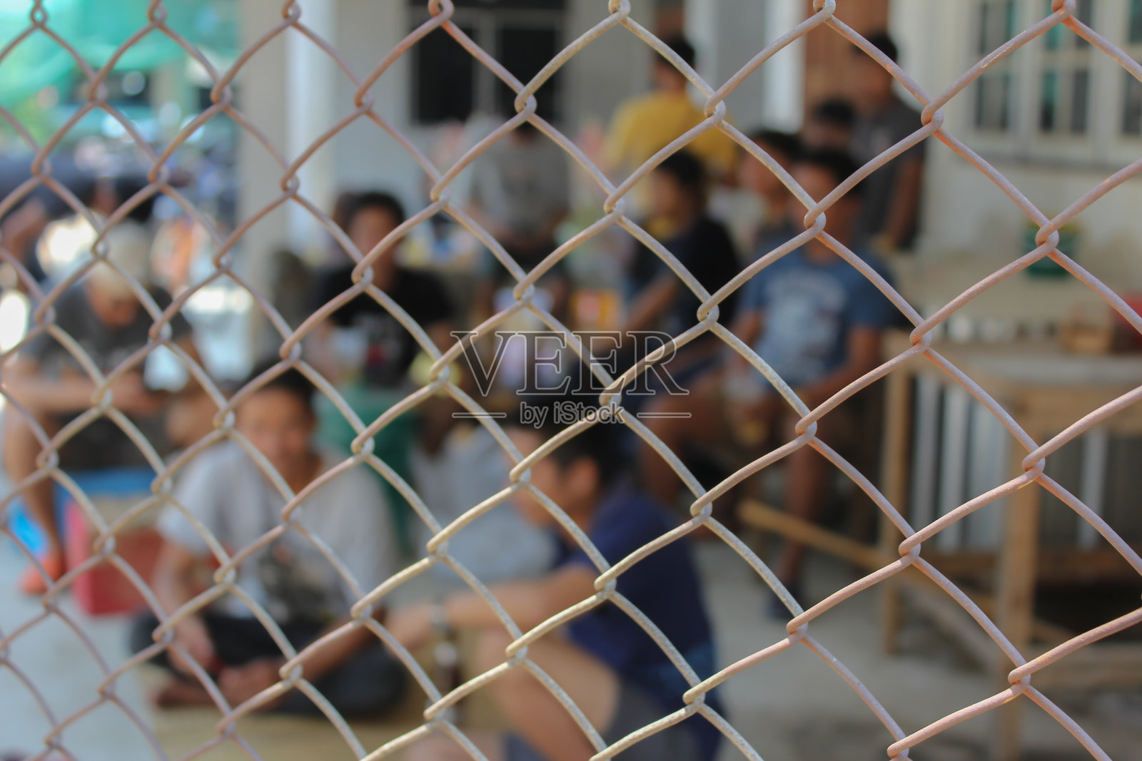 钢网围栏上挤满了人。照片摄影图片