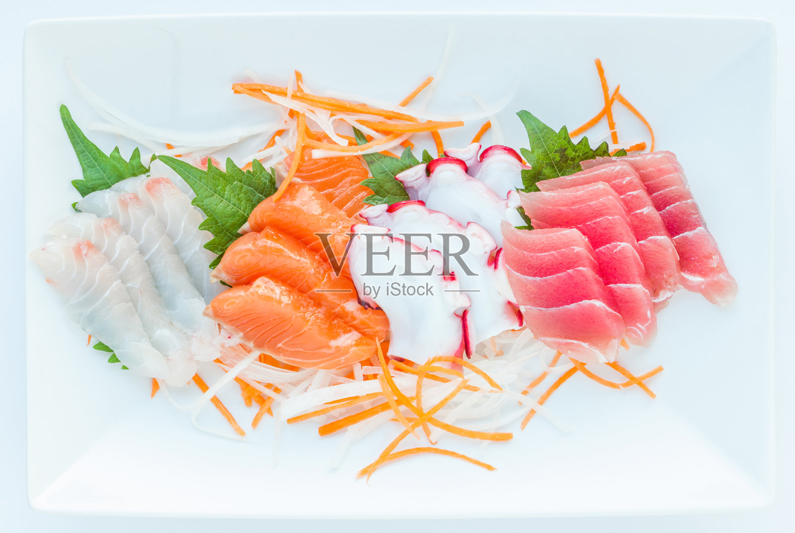 色彩鲜艳的生鱼片在白色日式盘子上。照片摄影图片