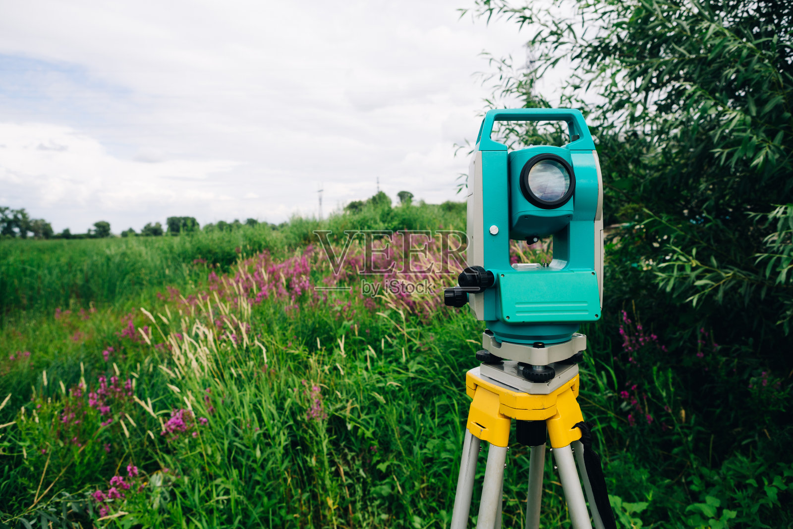 蓝色全站仪在背景草甸上照片摄影图片