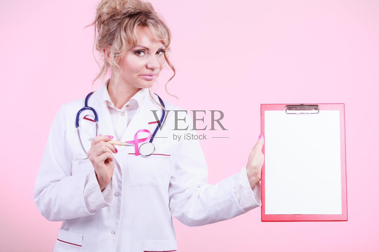 医生用钢笔展示带有粉红色丝带的文件夹。照片摄影图片