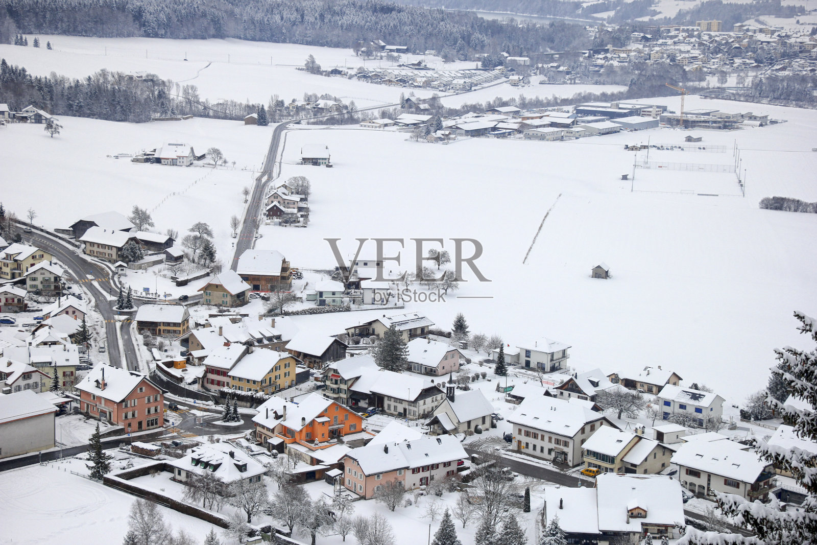 美丽的村庄覆盖了瑞士阿尔卑斯山附近的雪。照片摄影图片