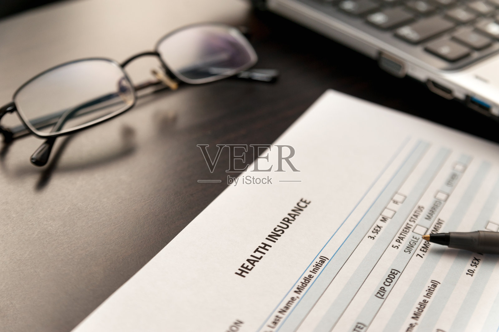 在一张木桌上填写健康保险表格照片摄影图片