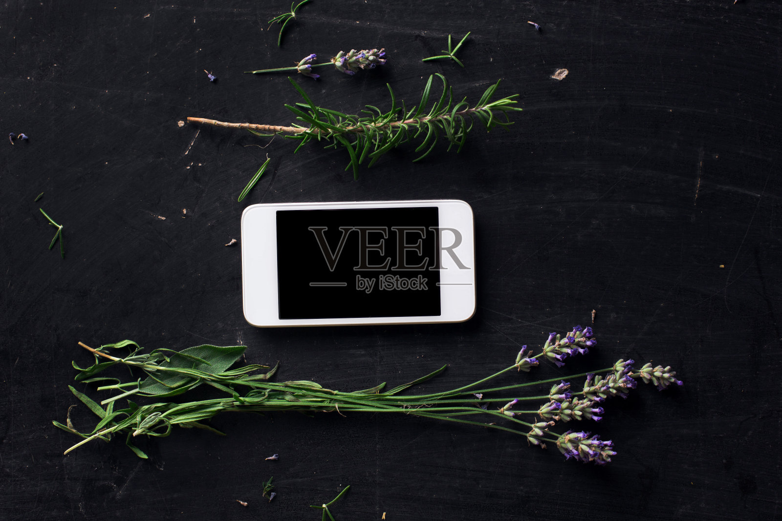 黑色书桌上的法国草药和电话俯视图照片摄影图片