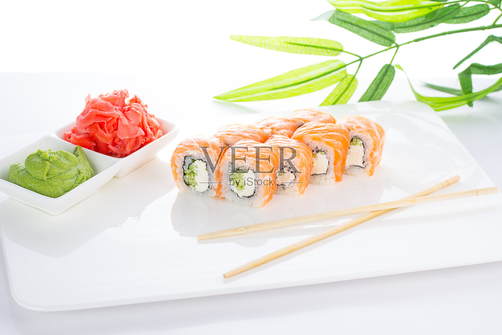 寿司卷放在白色盘子里，配上生姜和芥末照片摄影图片