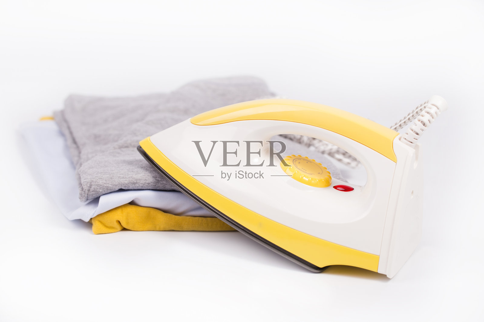 在白色的背景上熨烫和堆放衣服。照片摄影图片