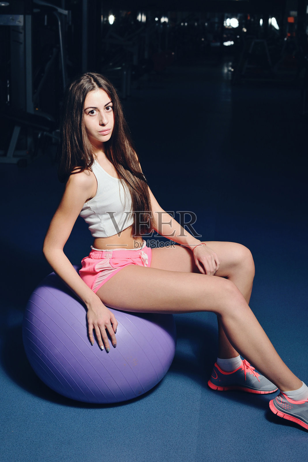 健身女孩在健身房的长椅上摆姿势照片摄影图片