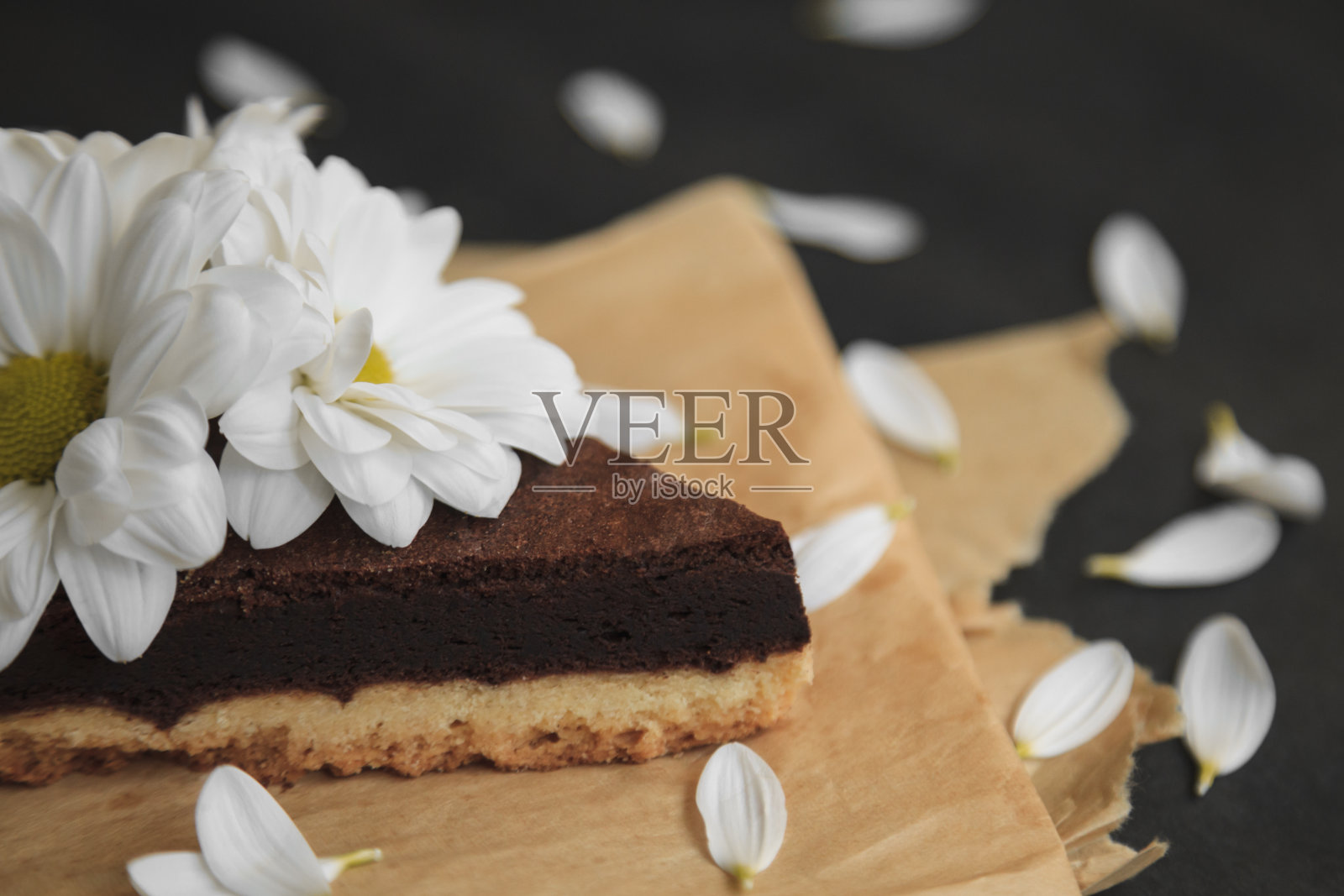 牛皮纸上有花的巧克力蛋糕照片摄影图片