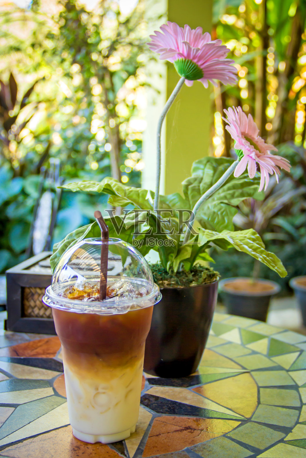 带回家的冰咖啡放在桌上。照片摄影图片