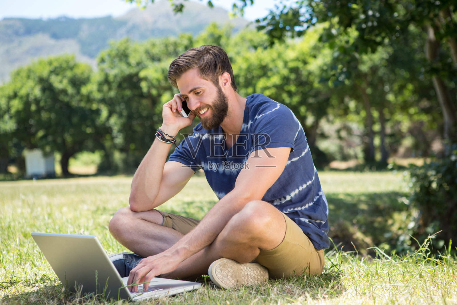 帅气的潮人在公园里使用笔记本电脑照片摄影图片