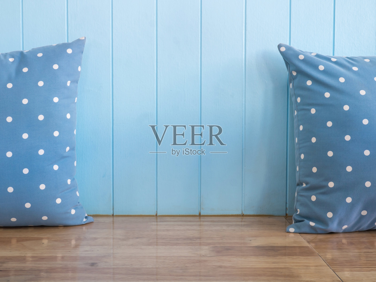 蓝色的木墙，木凳上放着圆点枕头照片摄影图片