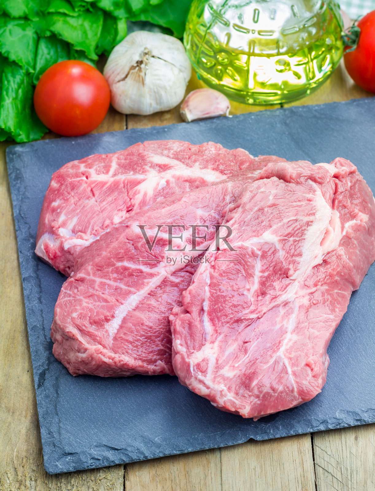 黑石板托盘上的生牛排照片摄影图片