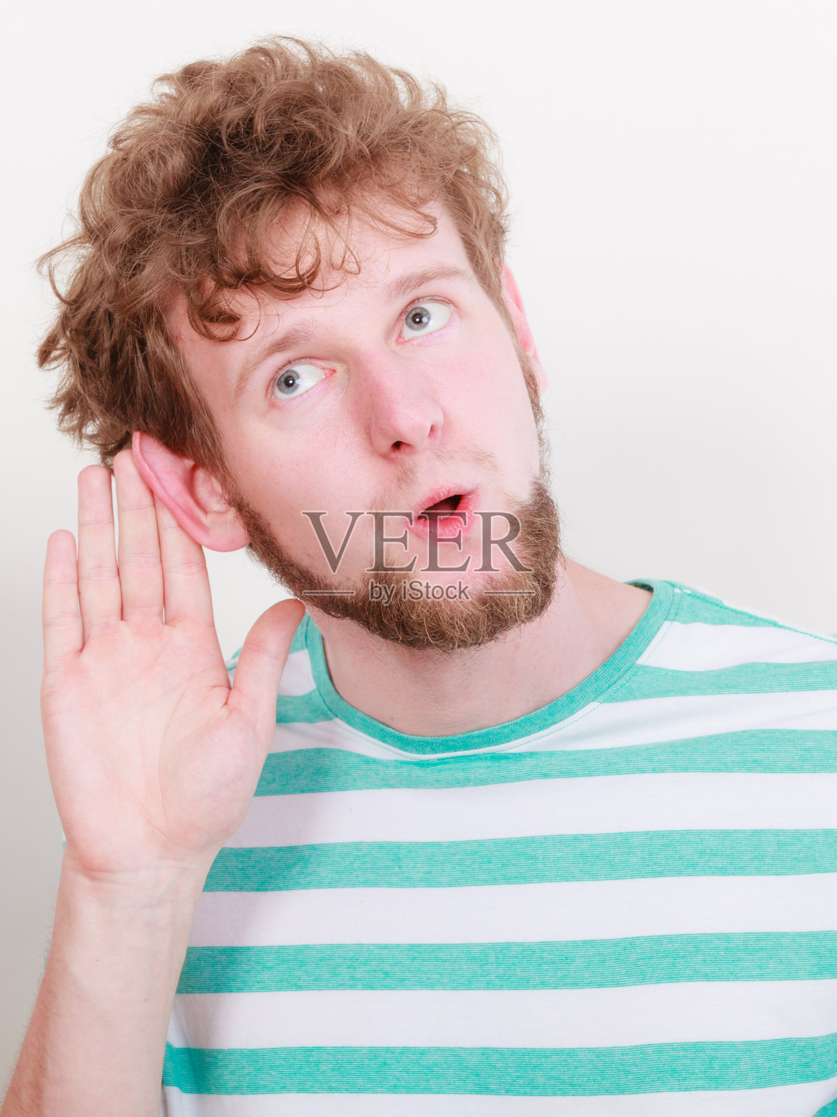 流言蜚语。年轻人手拉手，侧耳倾听照片摄影图片