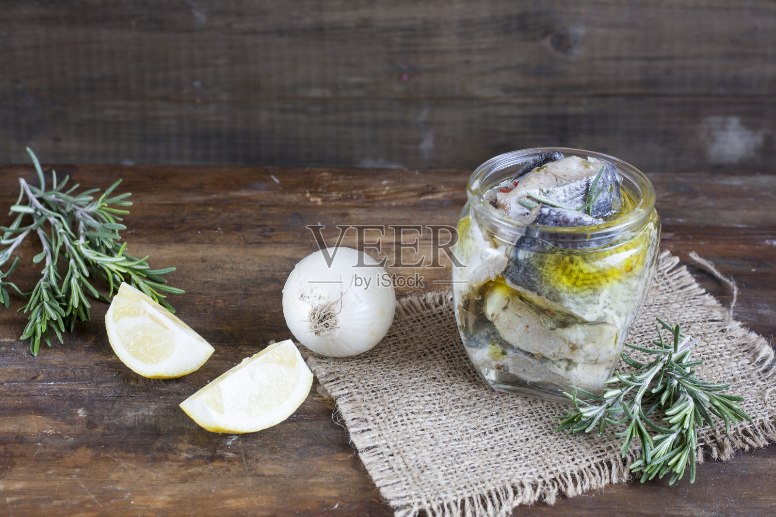 玻璃罐中腌制的鱼片。照片摄影图片