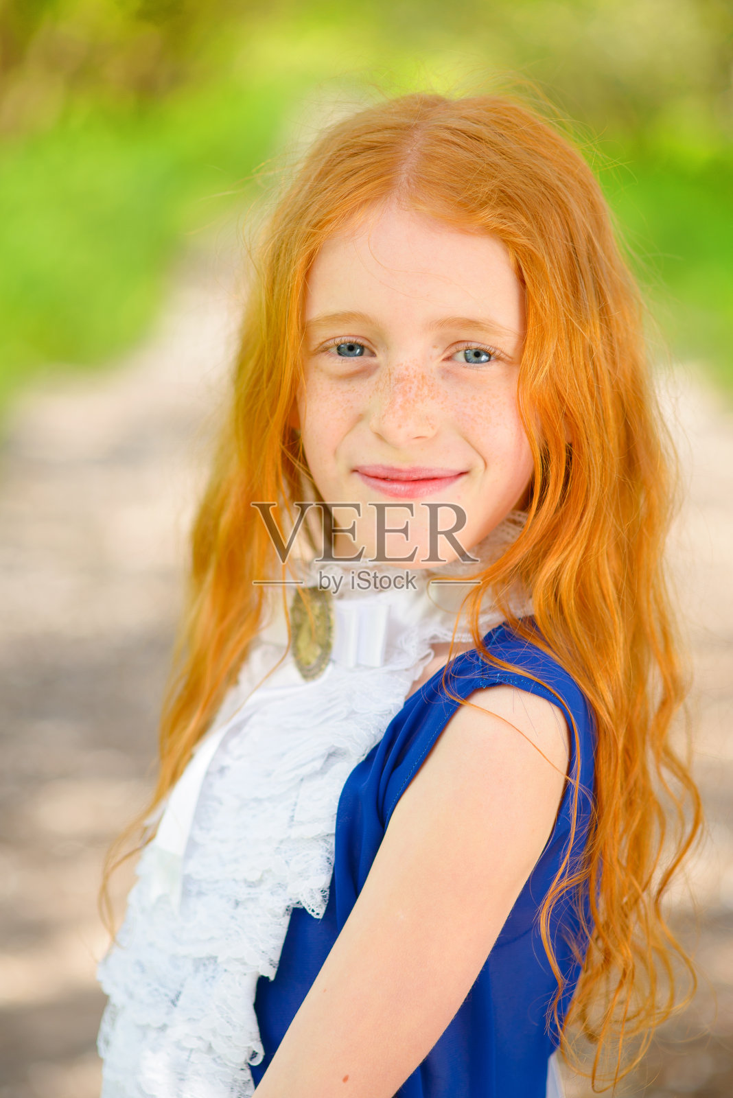 红发女孩在阳光灿烂的花园里照片摄影图片