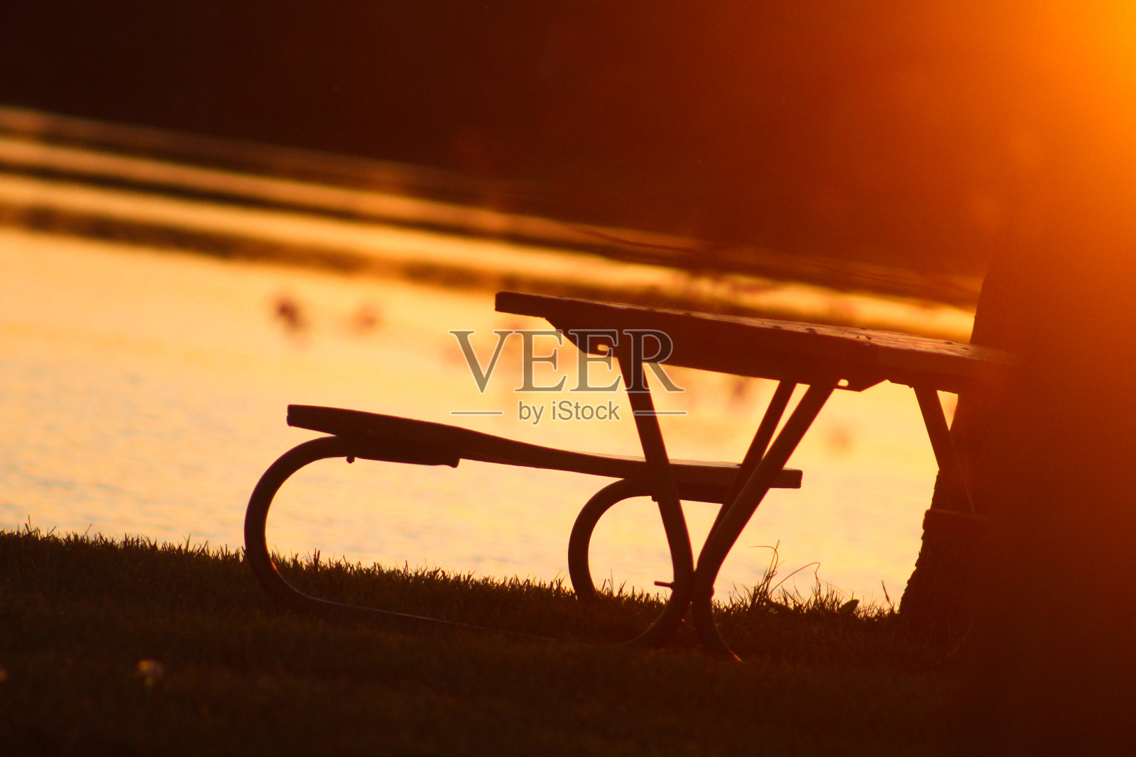 野餐桌，阳光照耀着湖面照片摄影图片