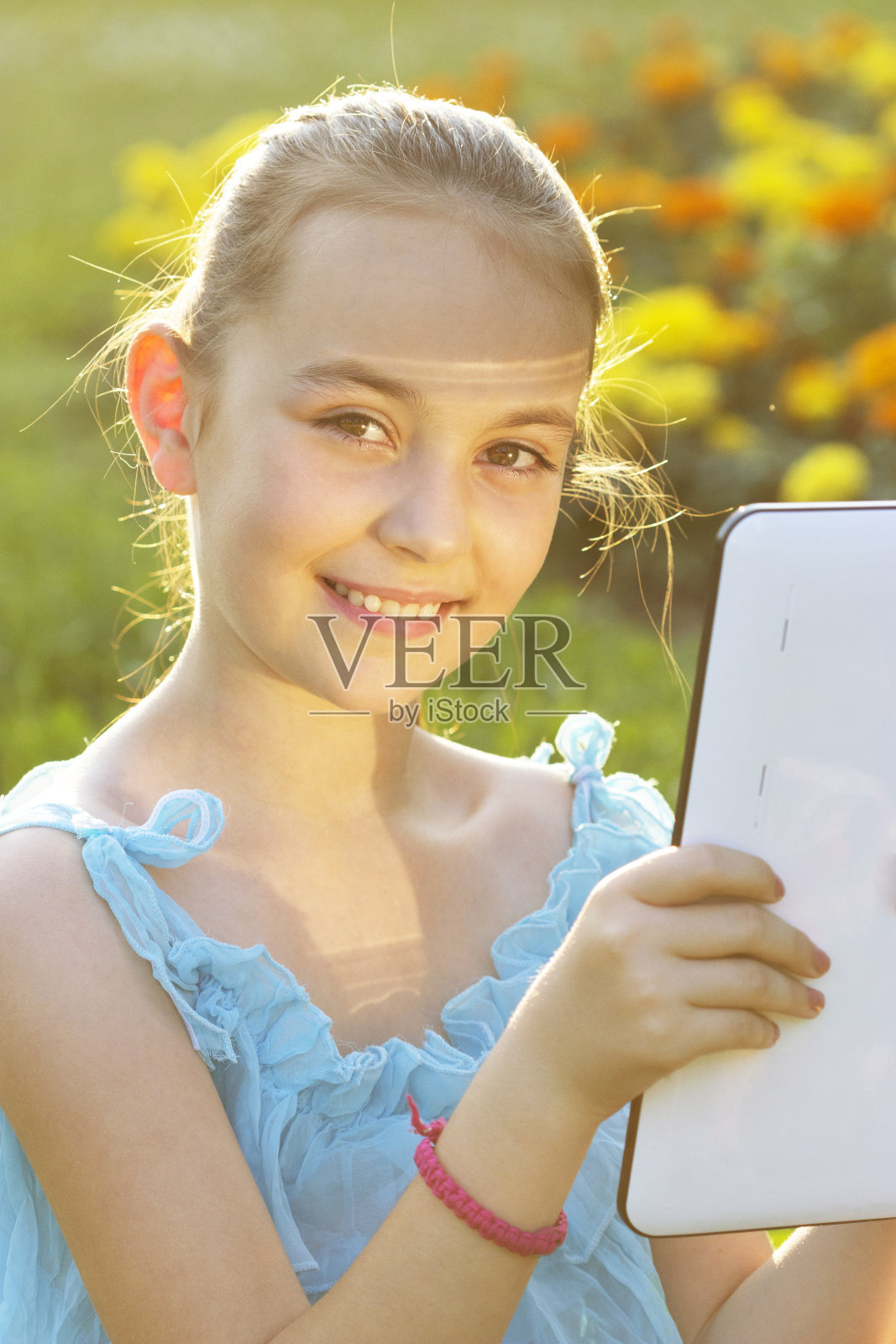 在公园里拿着平板电脑的女孩照片摄影图片