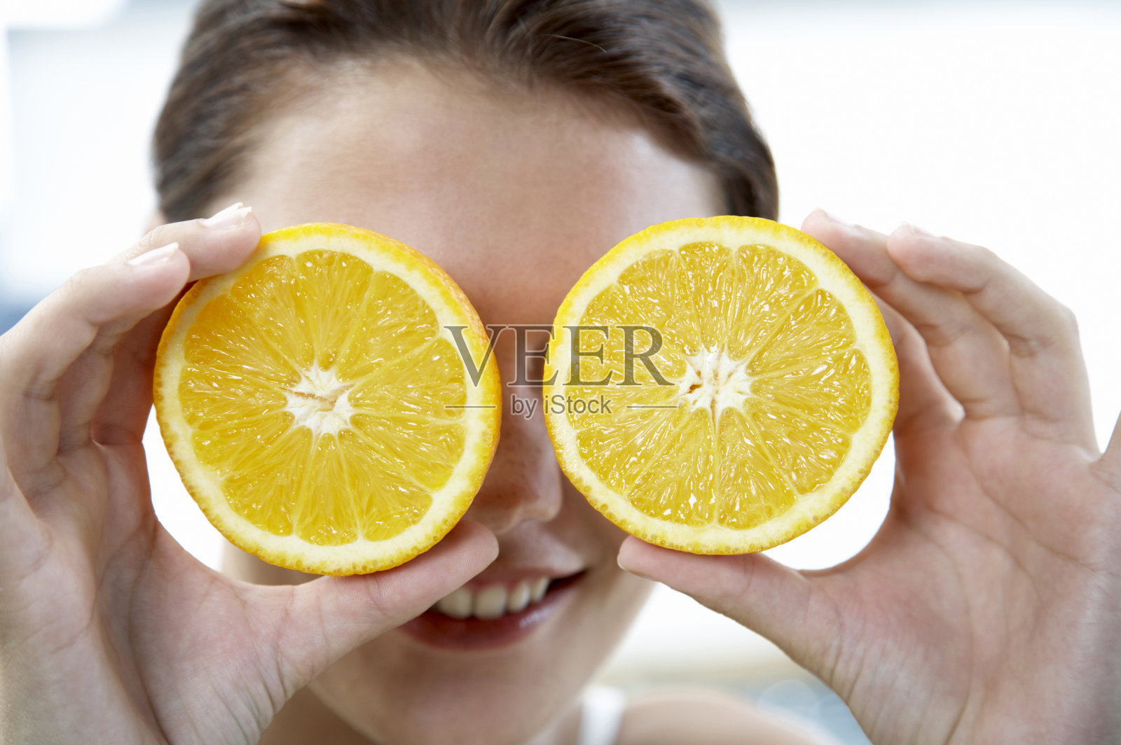 一个年轻的女人拿着切片的橘子照片摄影图片